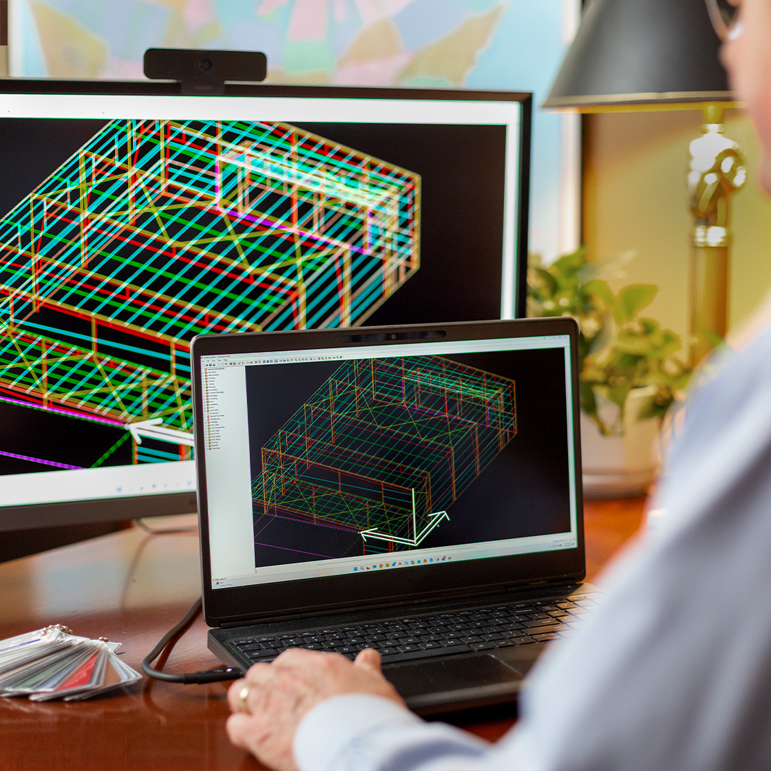Person using digital building design software on a laptop to model a steel structure concept during early project planning.